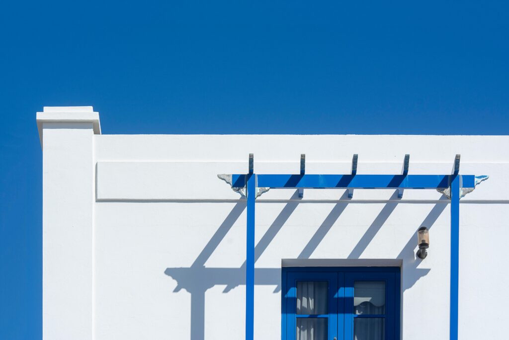 A minimalist white facade with blue accents under a clear blue sky in Lanzarote, Spain.